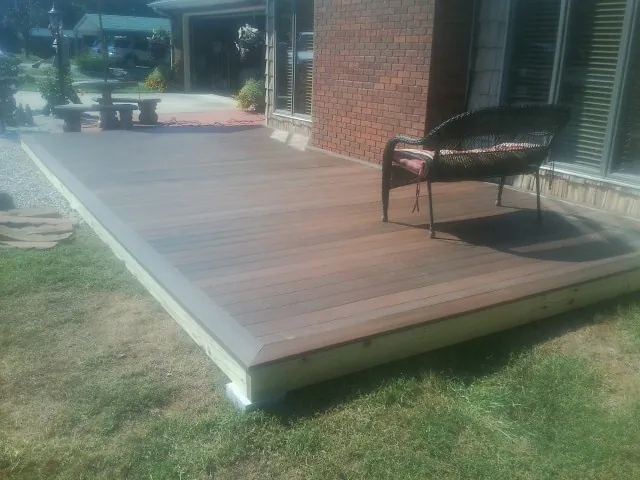 New wood deck and wicker chair beside a brick house in Smyrna